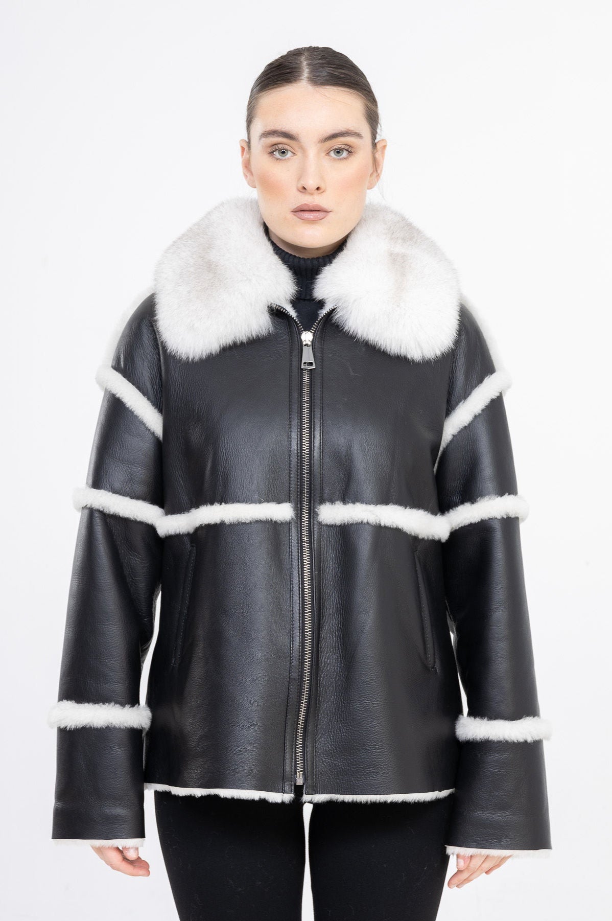 Black leather shearling jacket with white fur trim worn by Dimitri's model on a white background